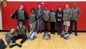 Group of robotics team members posed with Vex robots